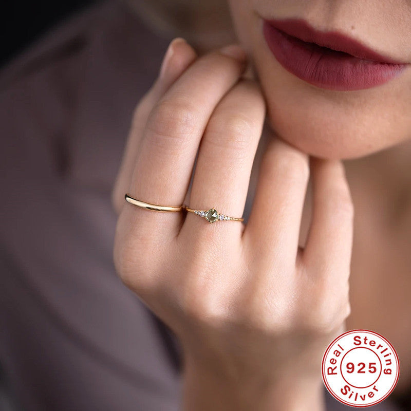Women's rings are fashionable and luxurious accessories, featuring a green gemstone and delicate gold band for elegant styling.