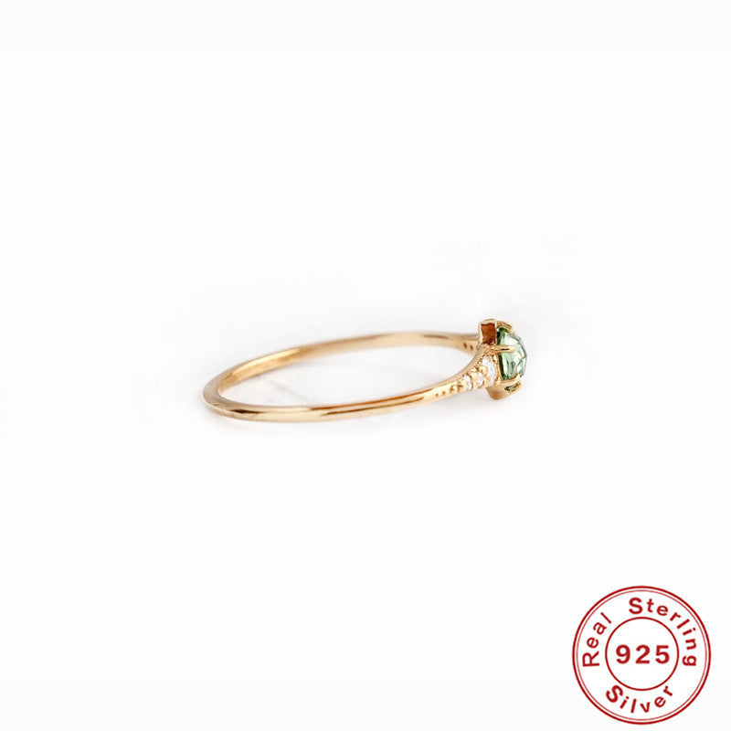 Women's rings are fashionable and luxurious accessories, shown in a side view with a green gemstone and 925 sterling silver gold-plated band.
